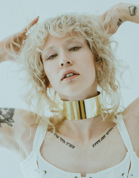 Model wearing thick gold band choker