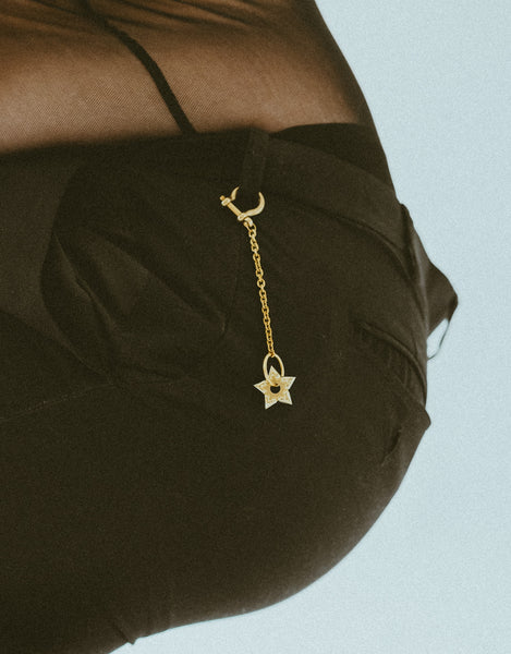 Close up of model with gold heart spur keychain on back belt loop