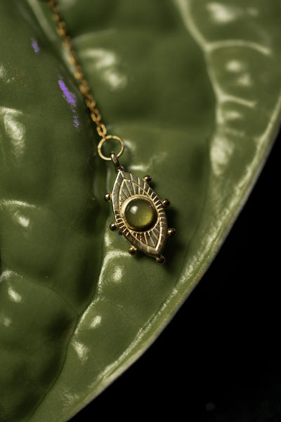 Green resin eye charm on a leaf