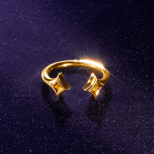 Gold star ring with a unique design on a dark blue velvet background