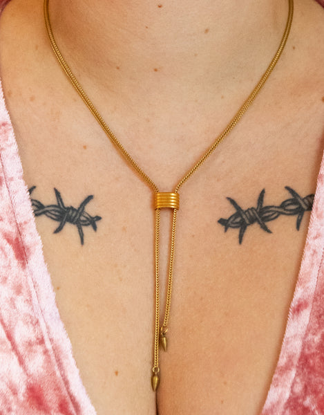 Close-up of gold cinched choker necklace with spike tips on a model