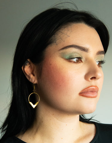 Side view of model wearing handmade brass hoop earrings