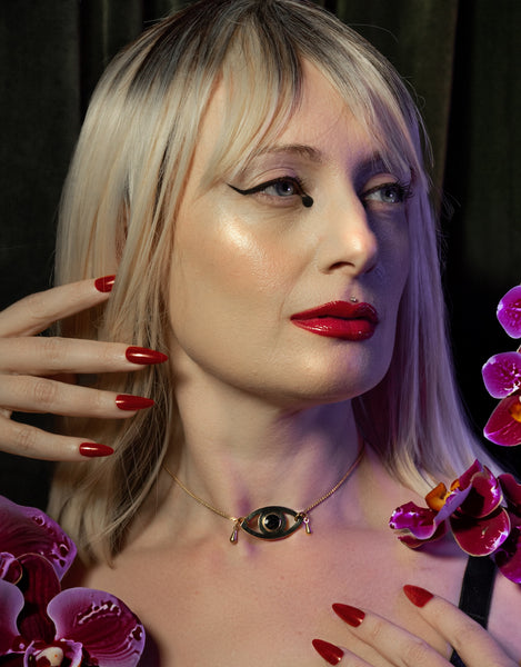 Model wearing gold eye pendant choker with teardrops