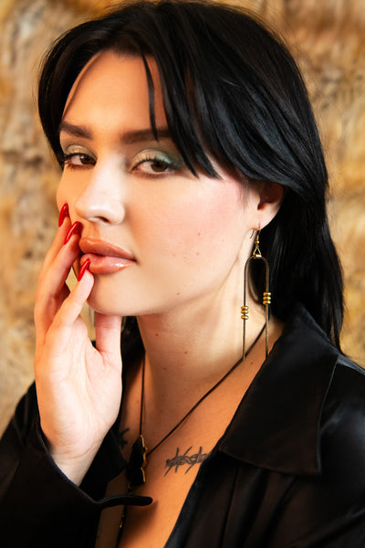 Model wearing black and gold vintage earrings
