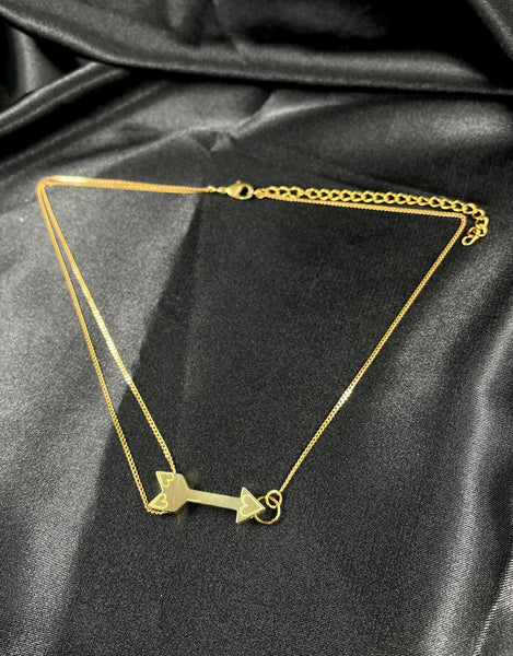 Gold arrow choker on a black silk background