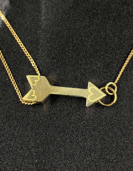 Close-up of gold arrow charm of choker