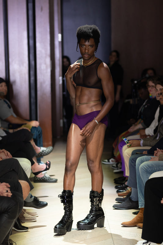 Side view of model on runway wearing gold belly chain