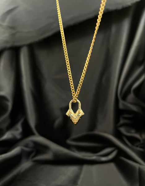 Close-up of back of gold heart charm with crown logo