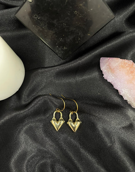 Heart locket charm earrings on a black silk background