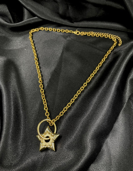Gold heart spur choker necklace on a black silk background