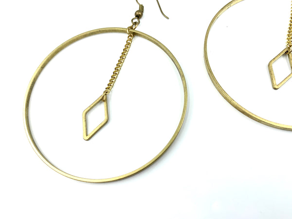 Close-up of diamond charm of large hoop earrings