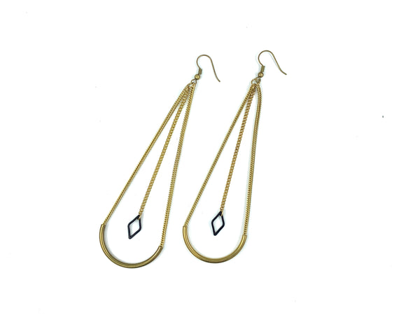 Long geometric brass earrings on a white background