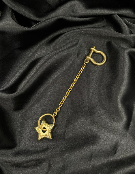Star spur keychain on a black silk background