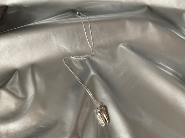Sterling silver tooth choker on a silver background