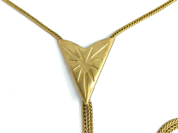 Close-up of starburst bolo tie pendant on a white background