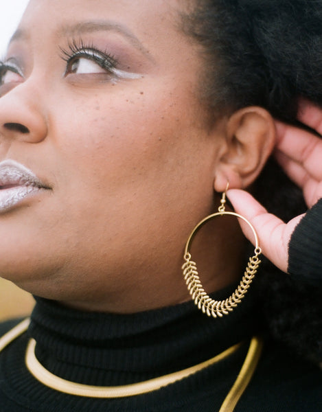 Brass fishbone chain earrings on a model