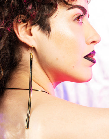 Side view of black tassel earrings on model