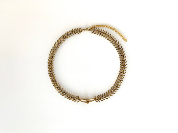 Top view of brass fishbone choker with chain link pendant, lobster clasp and extender chain