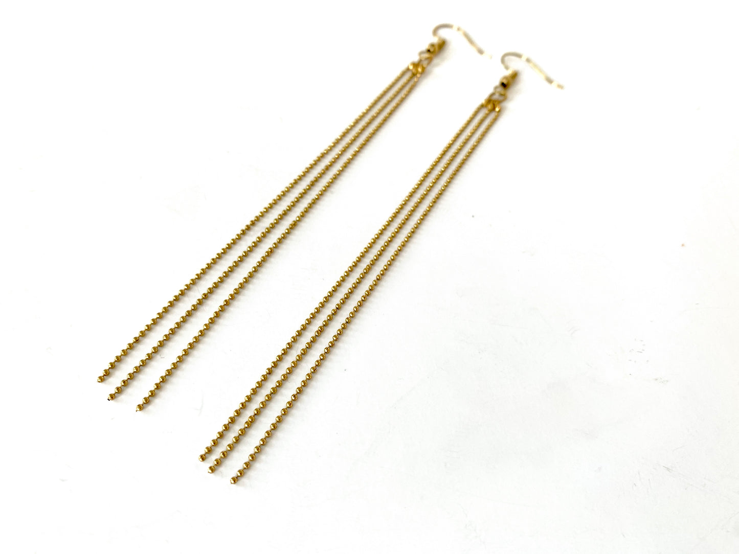 Close-up of ball chain tassels of earrings