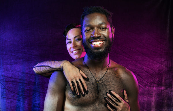 Model wearing black bolo tie necklace while being held by second model