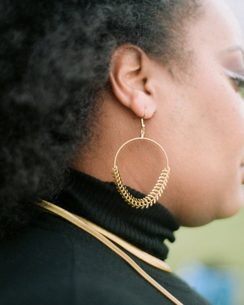 Side view of gold fishbone chain earrings