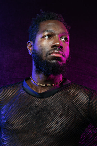 Model wearing chain link choker and black mesh shirt