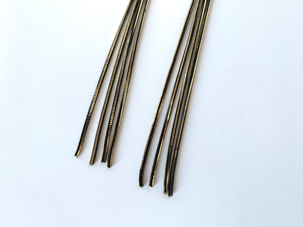 Close up of two tone chain of tassel earrings