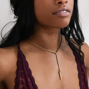 Model wearing gold lariat choker necklace