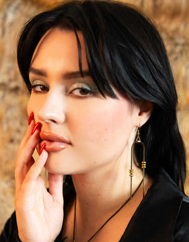 Model wearing handmade black and gold beaded snake chain earrings