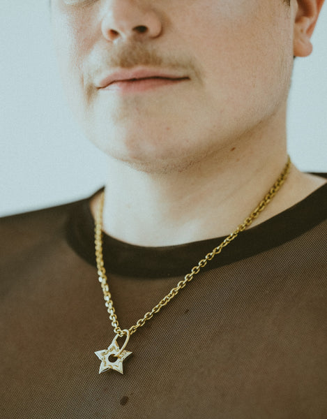 Close-up of model wearing gold spur choker and black mesh shirt