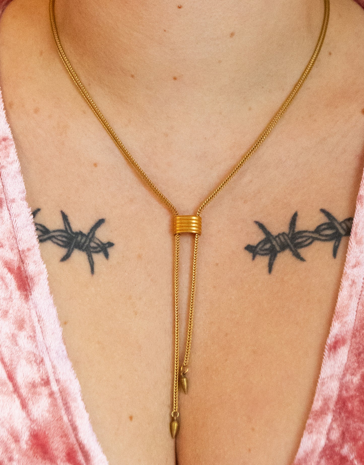 Close-up of gold cinched choker necklace with spike tips on a model