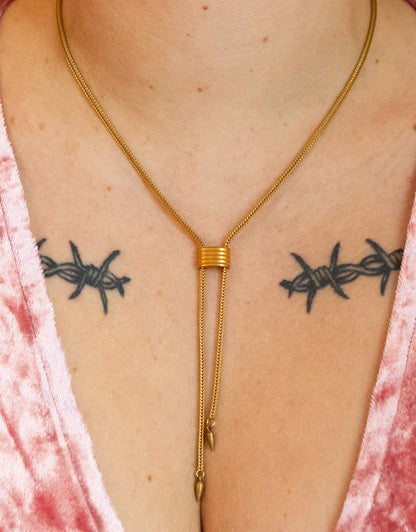 Close-up of gold cinched choker necklace with spike tips on a model