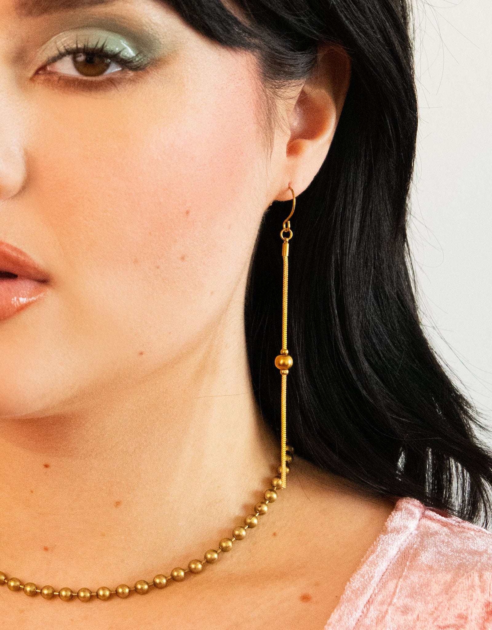Gold drop ball earrings on a model
