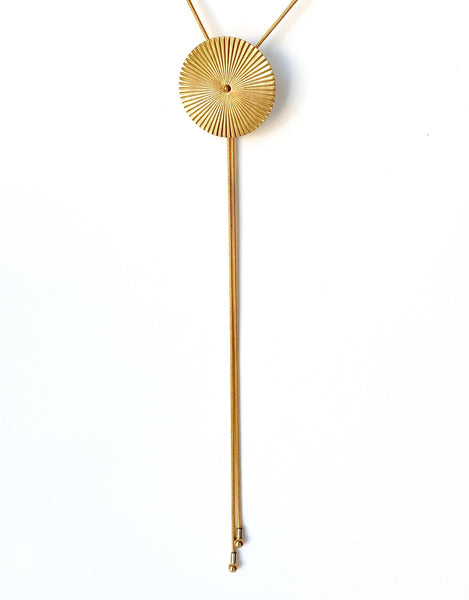 Gold bolo tie necklace on a white background