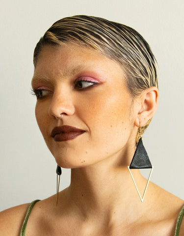 Model wearing recycled leather and brass triangle earrings
