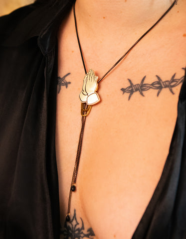 Close-up of model wearing gold praying hands bolo tie