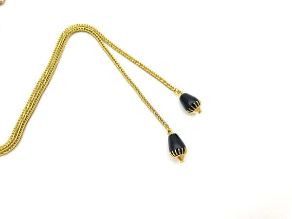 Close-up of onyx bolo tie tips with brass cap on white background