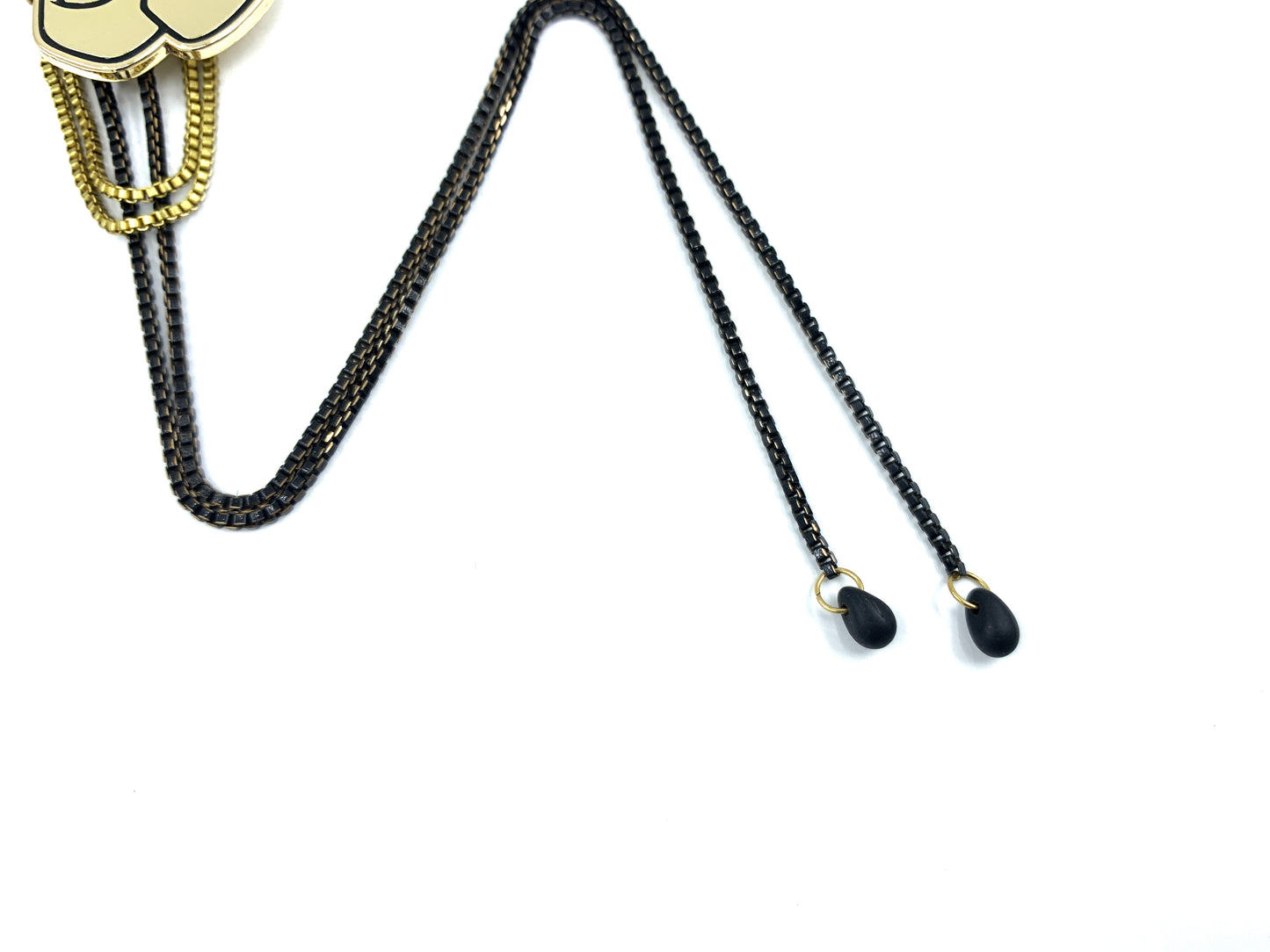 Close-up of black glass bead bolo tie tips on a white background
