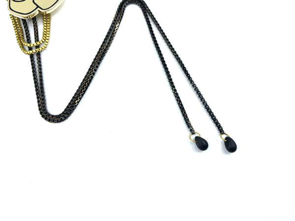 Close-up of black glass bead bolo tie tips on a white background