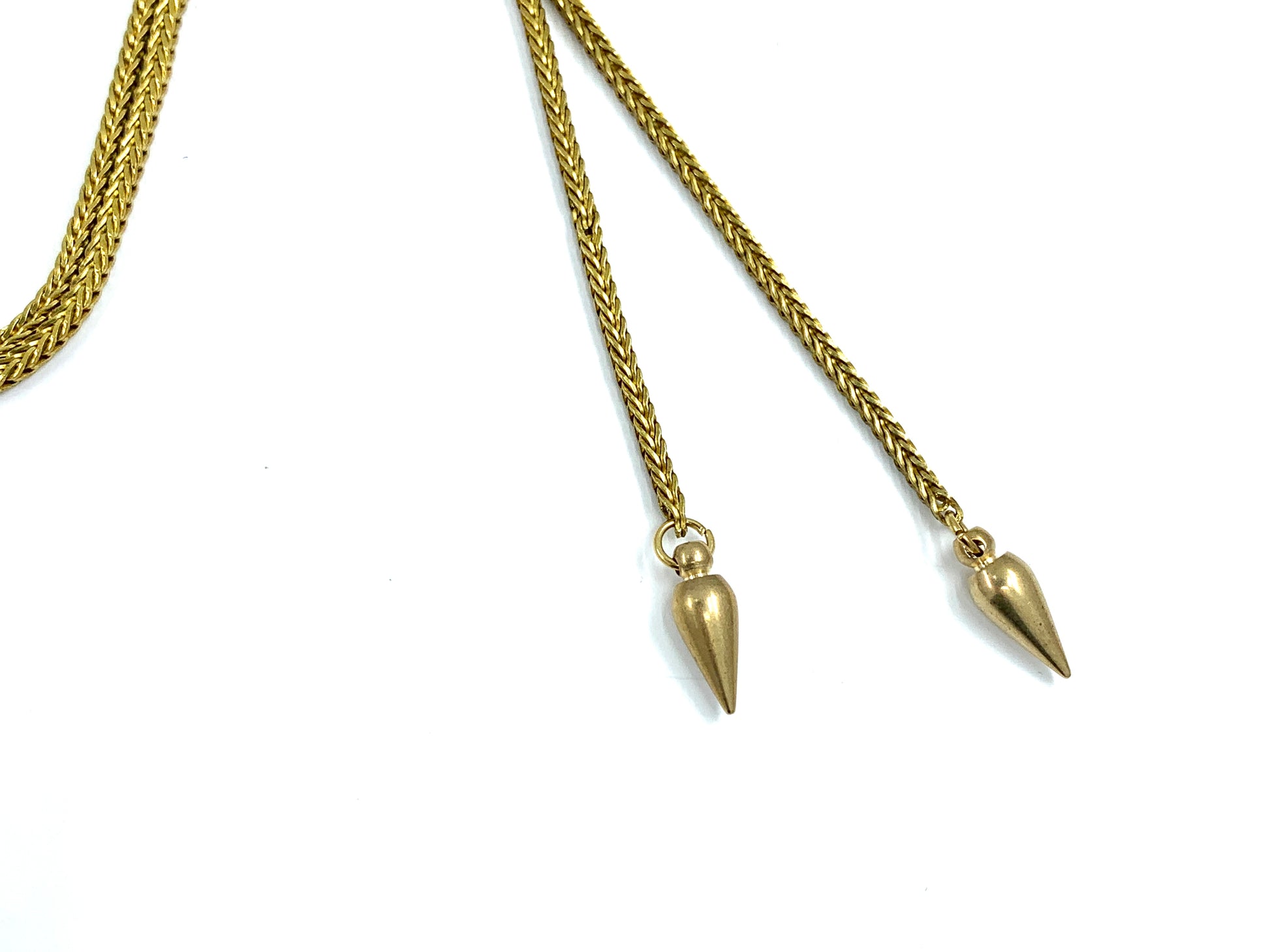 Close-up of brass spike bolo tie tips on a white background