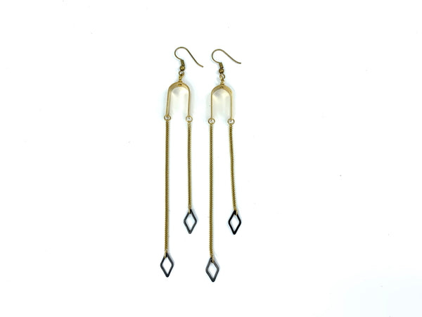 Asymmetric black and gold dangle earrings on a white background