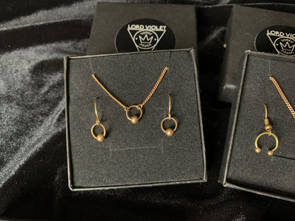 Captive barbell choker and earrings in a black gift box on a black velvet background