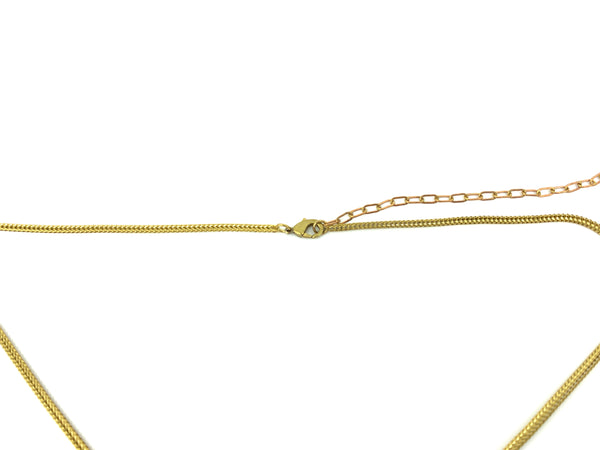 Close-up of gold lobster clasp of choker necklace on a white background