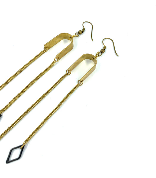 Close-up of brass dangle earring hooks on a white background