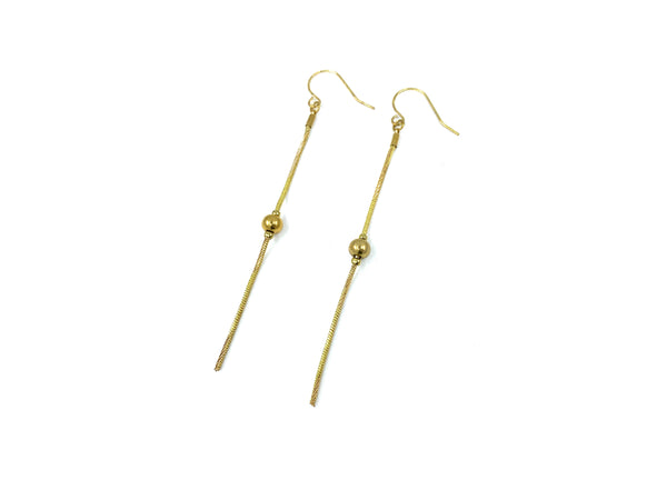 Gold bead drop earrings on a white background