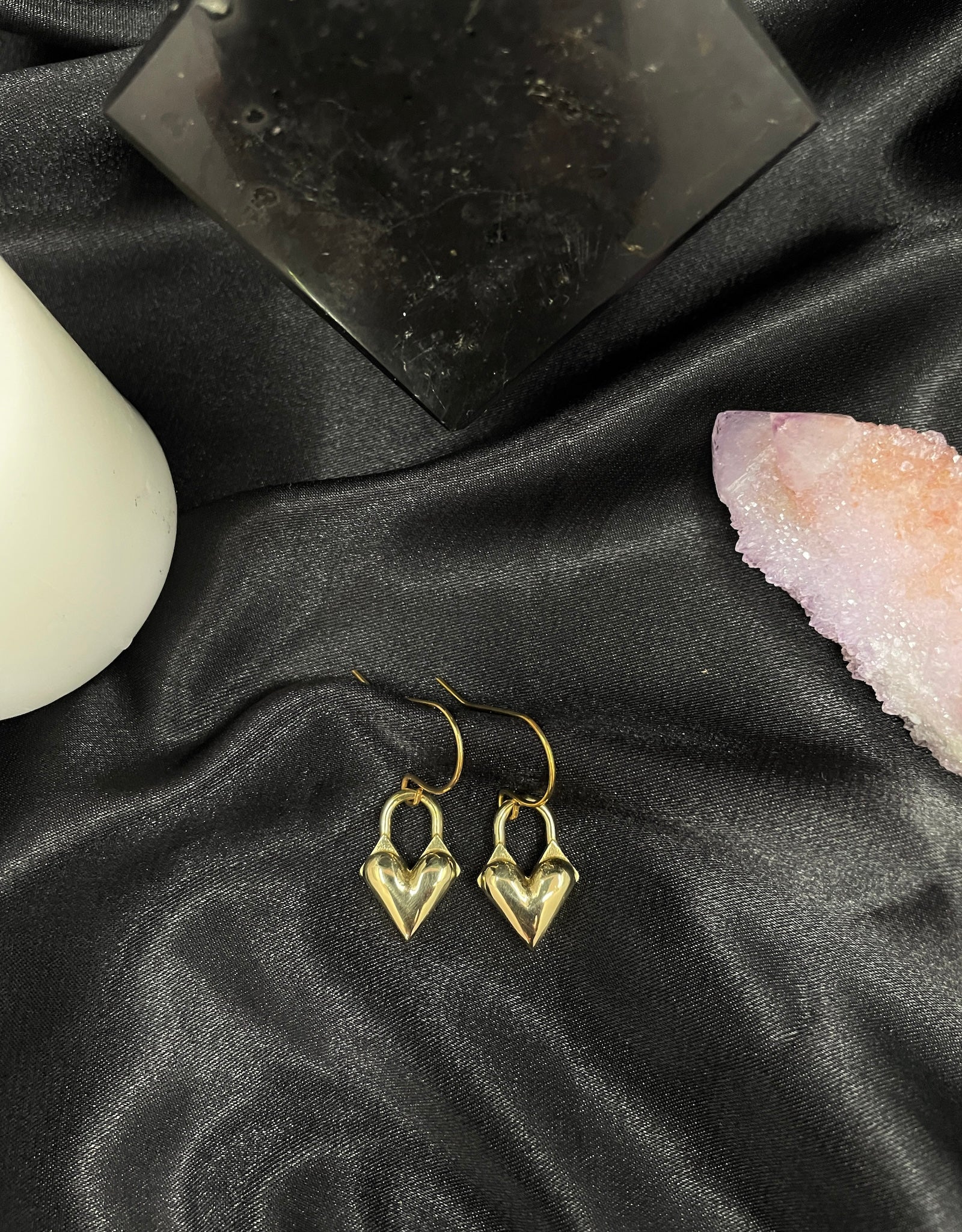 Heart locket charm earrings on a black silk background
