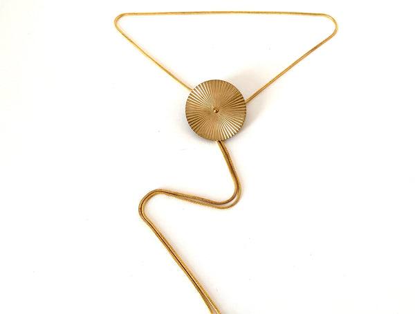 Pendant of gold bolo tie necklace on a white background