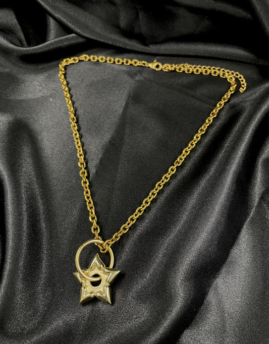 Gold heart spur choker necklace on a black silk background