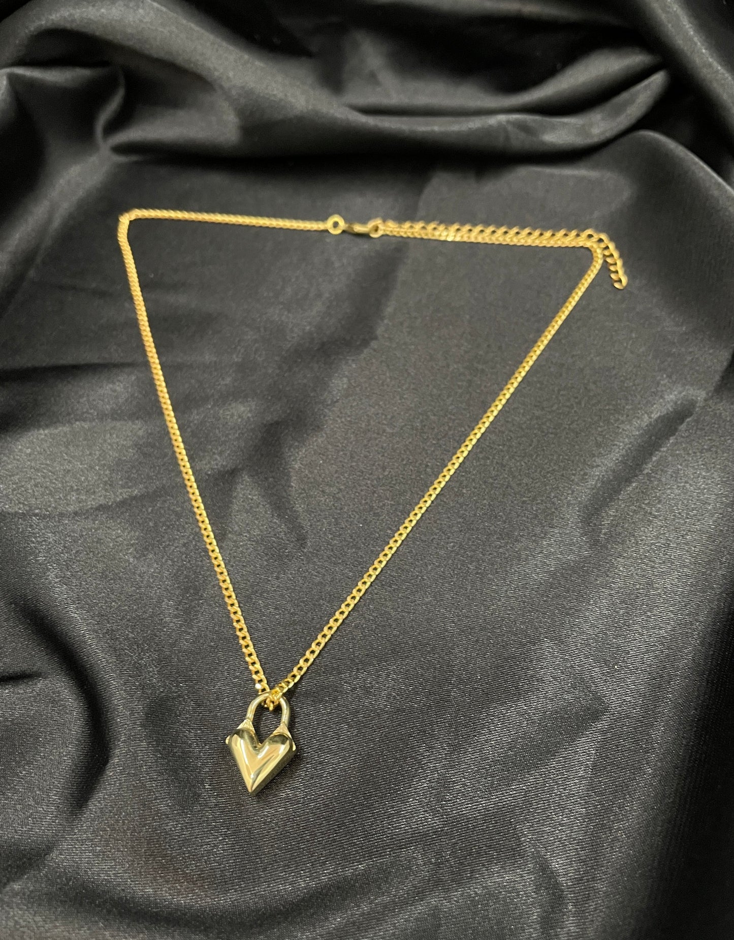 Gold heart locket choker on a black silk background