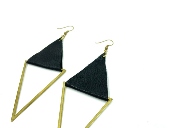 Close-up of black and gold geometric earrings on a white background